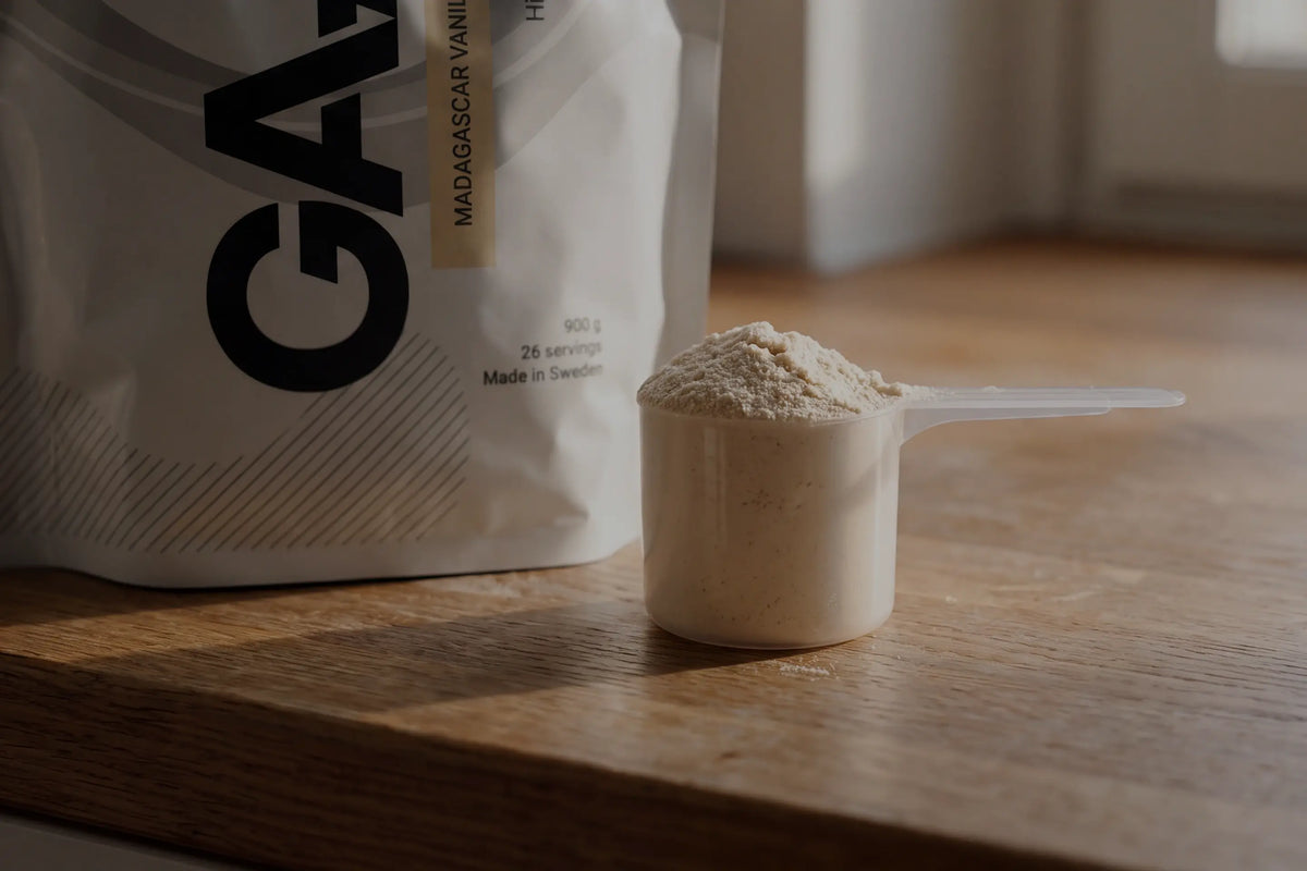 Skopa med proteinpulver på ett träbord, ett praktiskt proteintillskott vid viktminskning