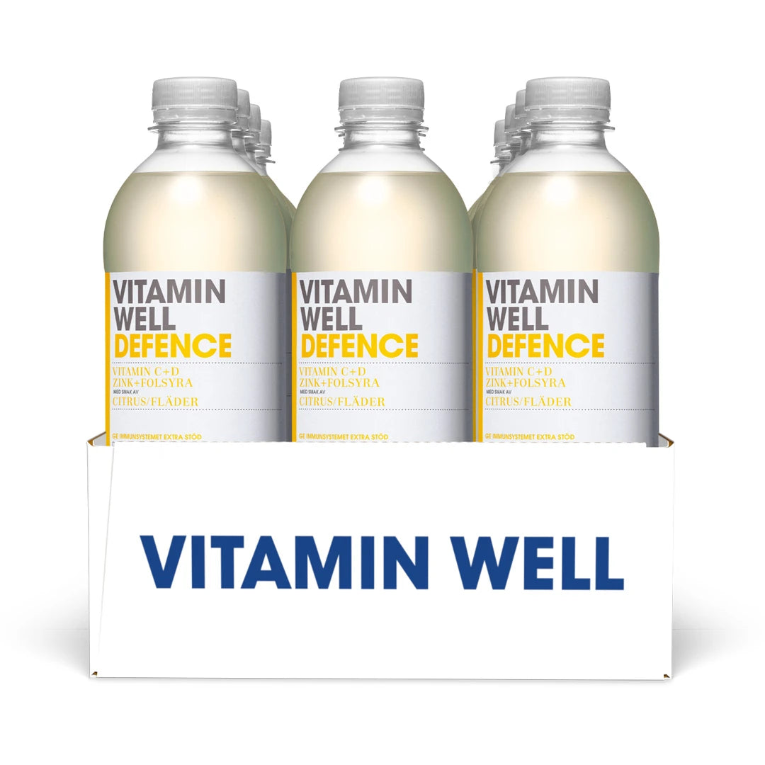 12 x Vitamin Well 500 ml Defence Citrus Fläder presenterat i en vit förpackning med tolv genomskinliga plastflaskor med vita etiketter.