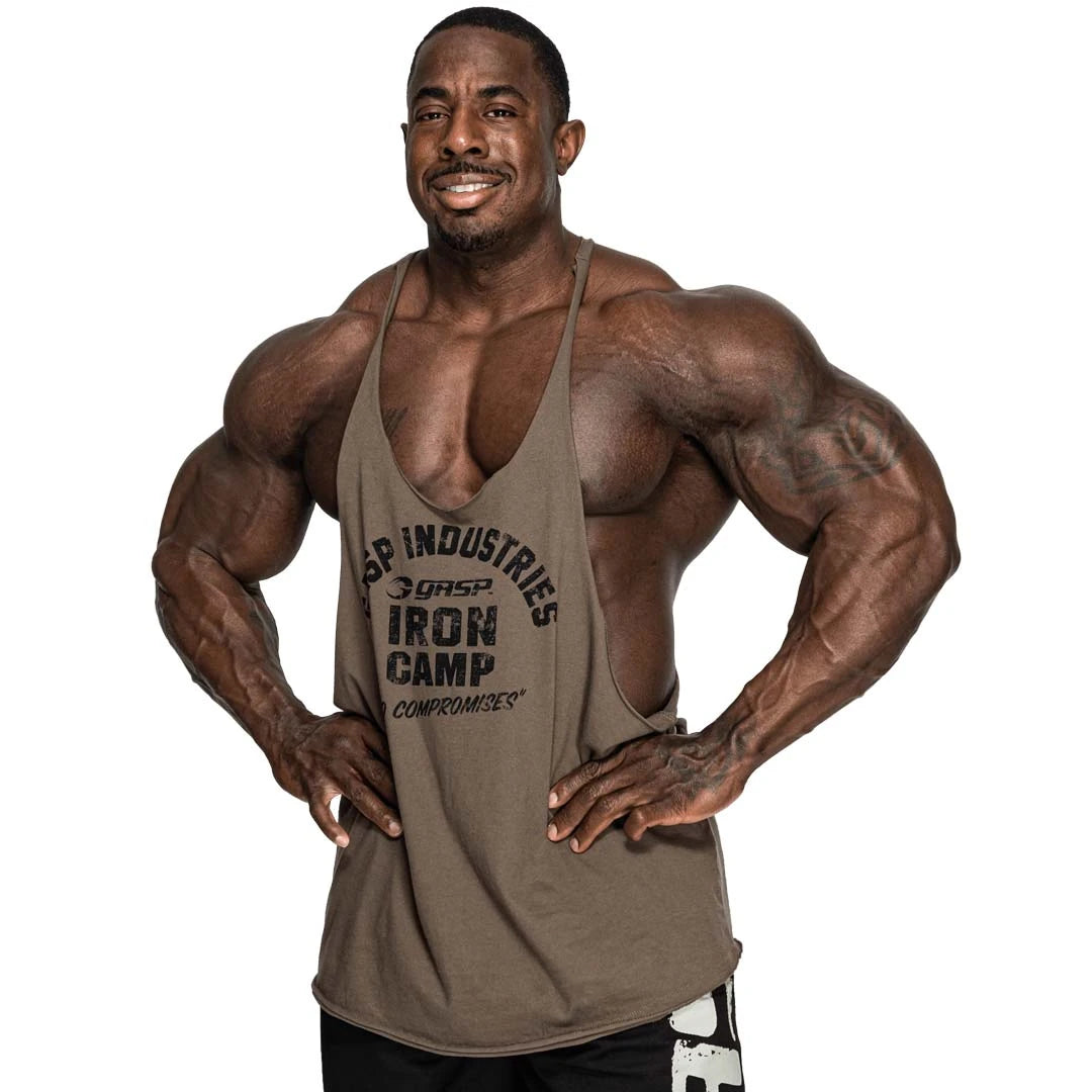 GASP Stringer Tank Washed Green, ett grönt stringerlinne i bomull med svart tryck buret av en muskulös man., bild 1 av 2