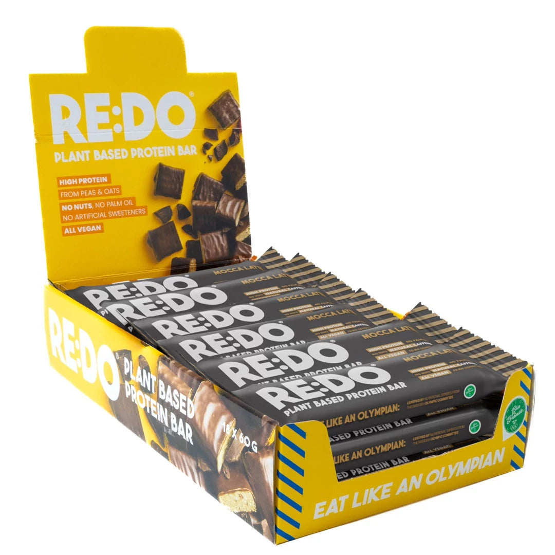 18 x REDO Koffein Bar 60 g i en gul displaylåda fylld med mörka proteinbars i smaken Mocca Latte., bild 1 av 1