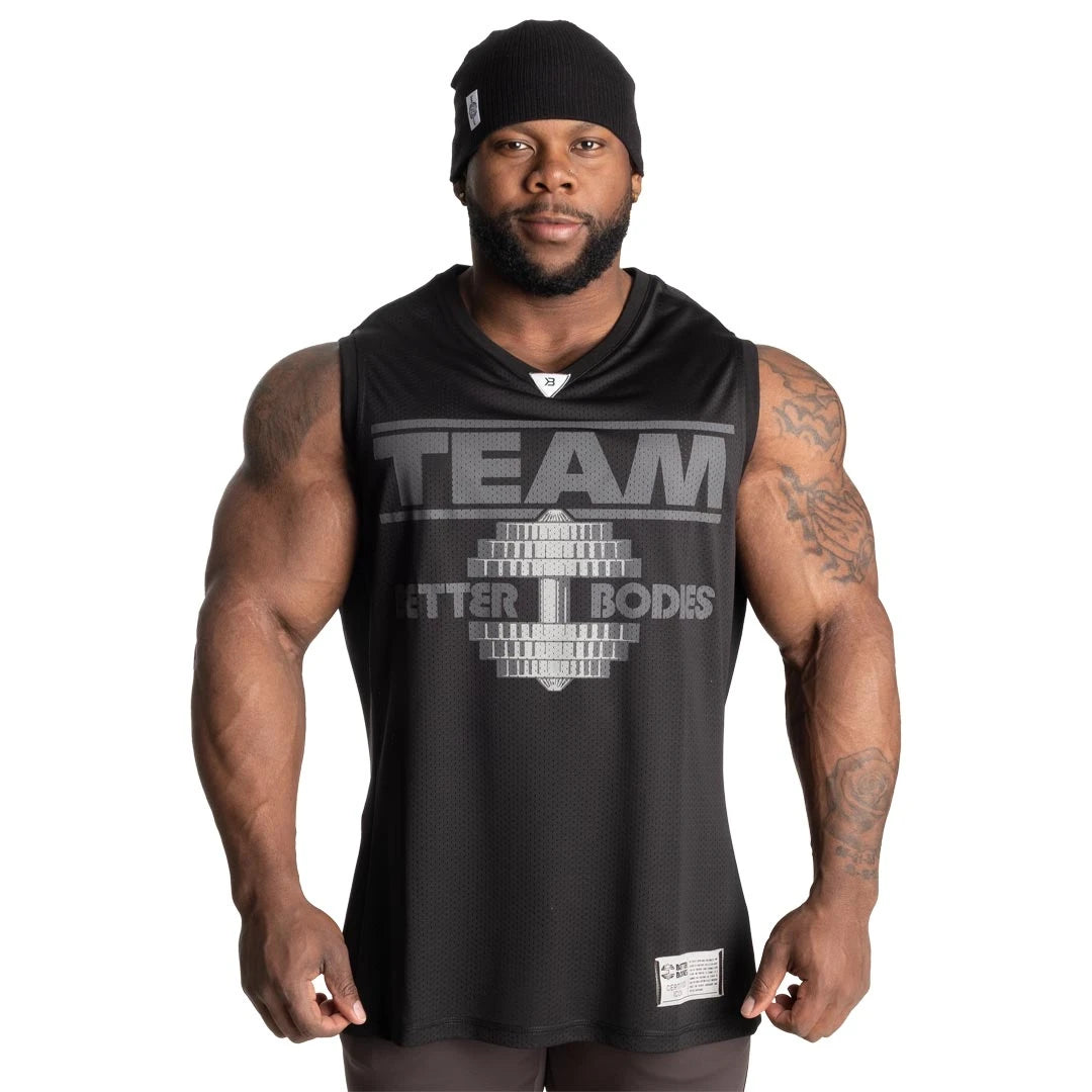 Better Bodies Iron Mesh Tank Black, ett svart träningslinne i mesh med stort brösttryck buret av en man.