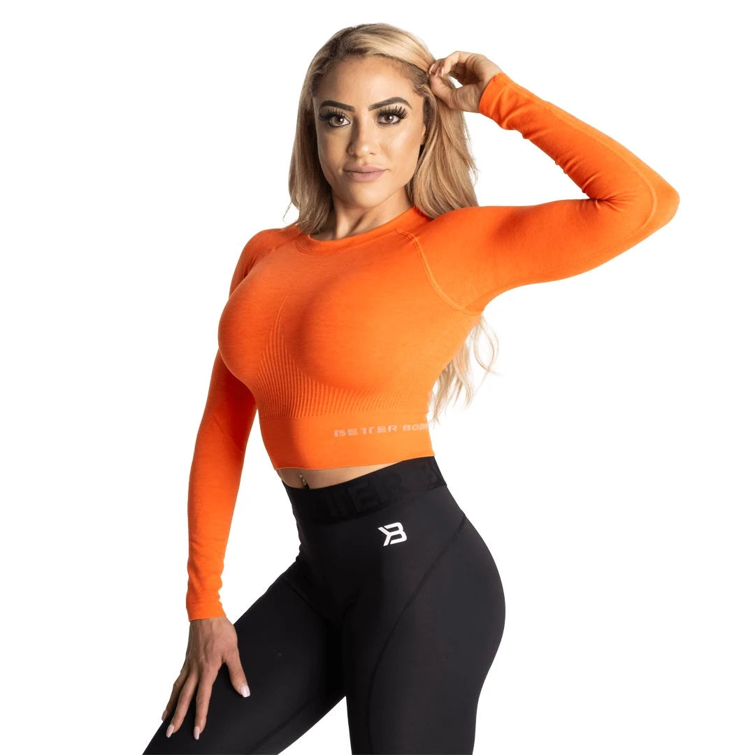 Orange Better Bodies Rib Seamless Crop LS Sunset Melange, en långärmad och ribbad croptop buren av en modell., bild 2 av 2