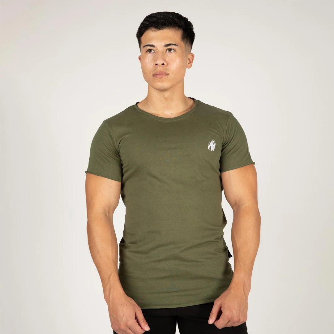 Gorilla Wear York T-Shirt Green i mjuk grön bomull med slim fit och råa kanter, buren av en modell.