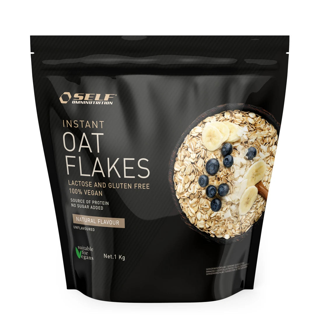 Self Omninutrition Instant Oat Flakes 1 kg förpackad i en svart påse med motiv av en skål havregryn och bär.
