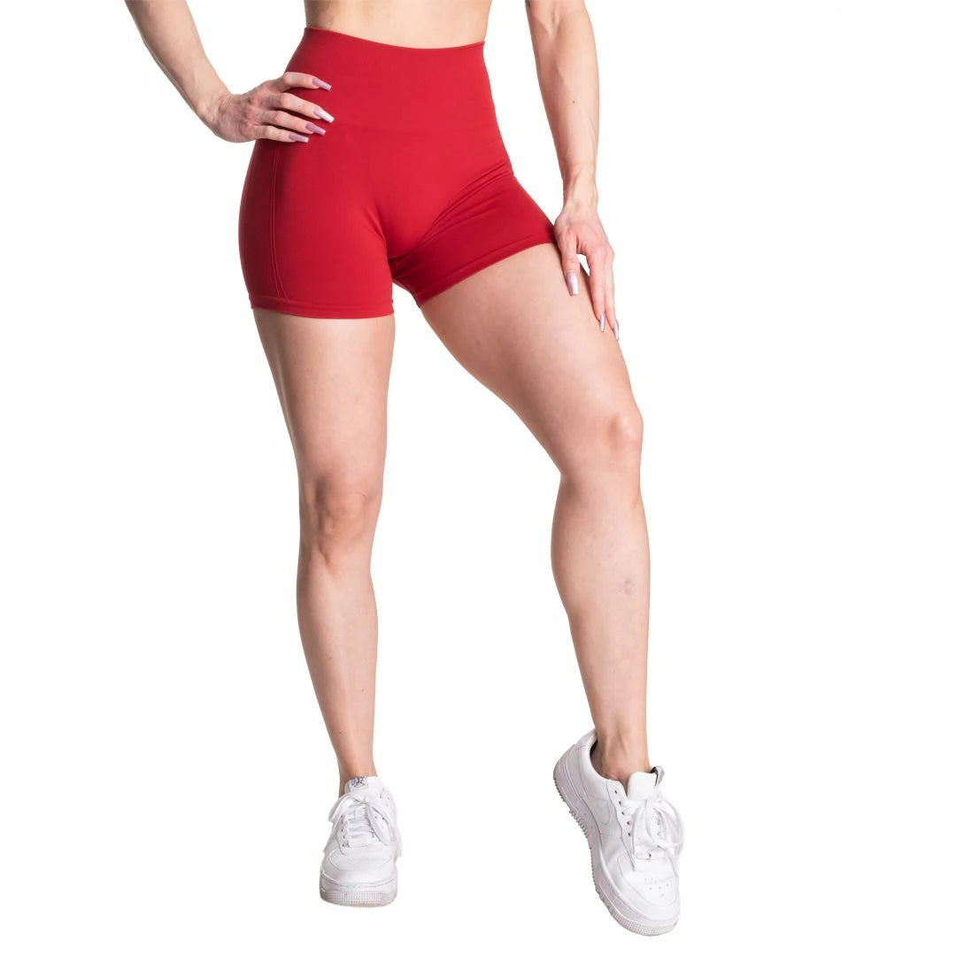 Better Bodies Scrunch Shorts Chili Red, röda träningsshorts med hög midja som bärs av en modell., bild 1 av 2