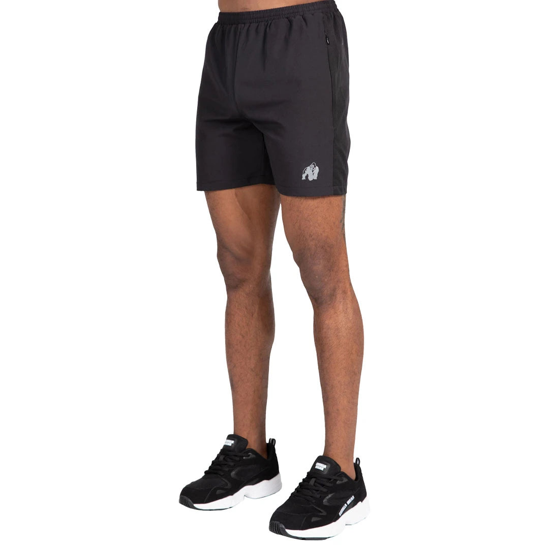 Gorilla Wear Lubec Shorts Black på modell, svarta träningsshorts med dolda fickor och reflexlogga.