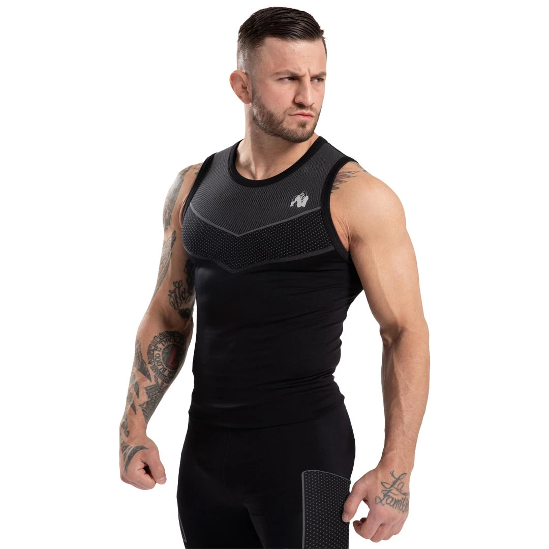Gorilla Wear Norton Seamless Tank Top Black, ett svart kroppsnära träningslinne med grå detaljer, på en manlig modell., bild 3 av 6