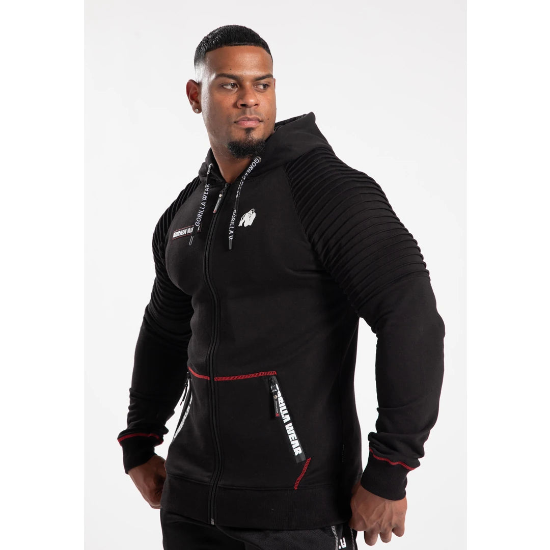Gorilla Wear Georgia Zipped Hoodie Black med ribbat axelparti, vita logotyper och dragkedja på en manlig modell., bild 5 av 8