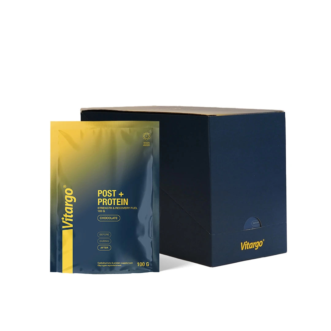 Vitargo Post Protein 15 x 100 g choklad, mörkblå och gul portionspåse stående bredvid en mörkblå kartong.