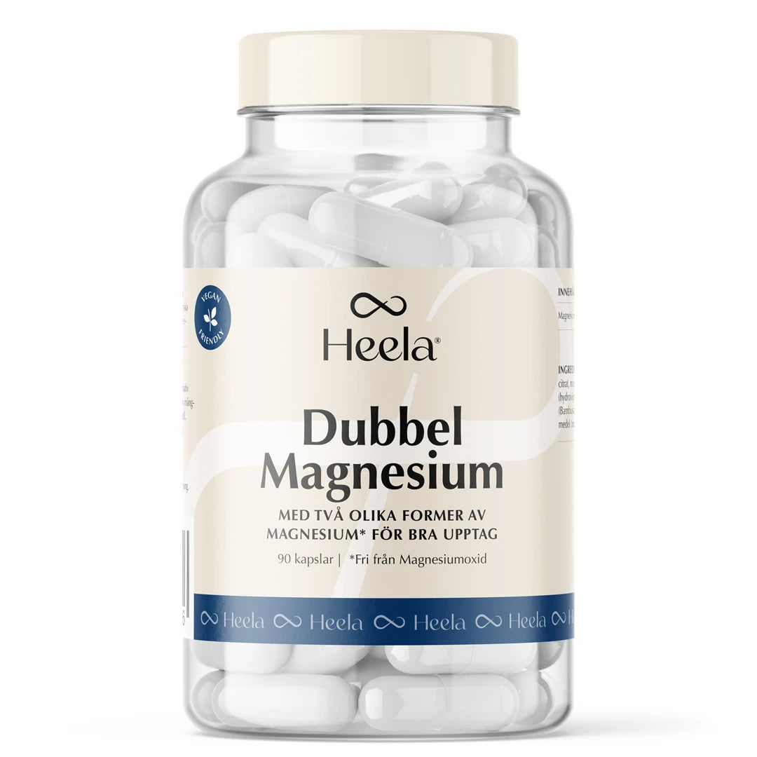 Heela Dubbel Magnesium 90 caps kosttillskott i en genomskinlig burk med ljus etikett, fylld med vita kapslar.