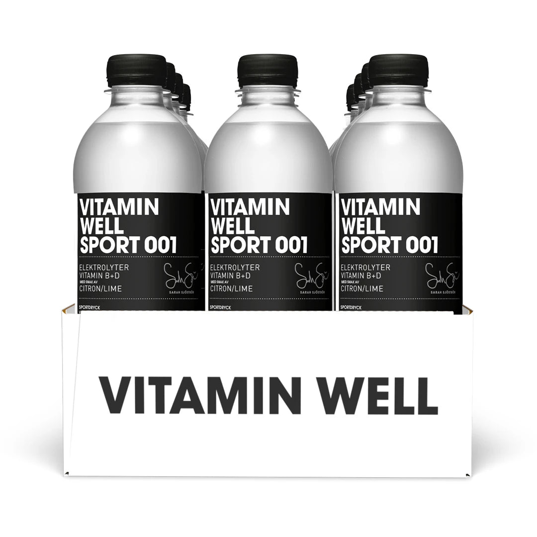 12 x Vitamin Well Sport 500 ml 001 - Lemon Lime i ett vitt flak med genomskinliga plastflaskor och svarta etiketter.