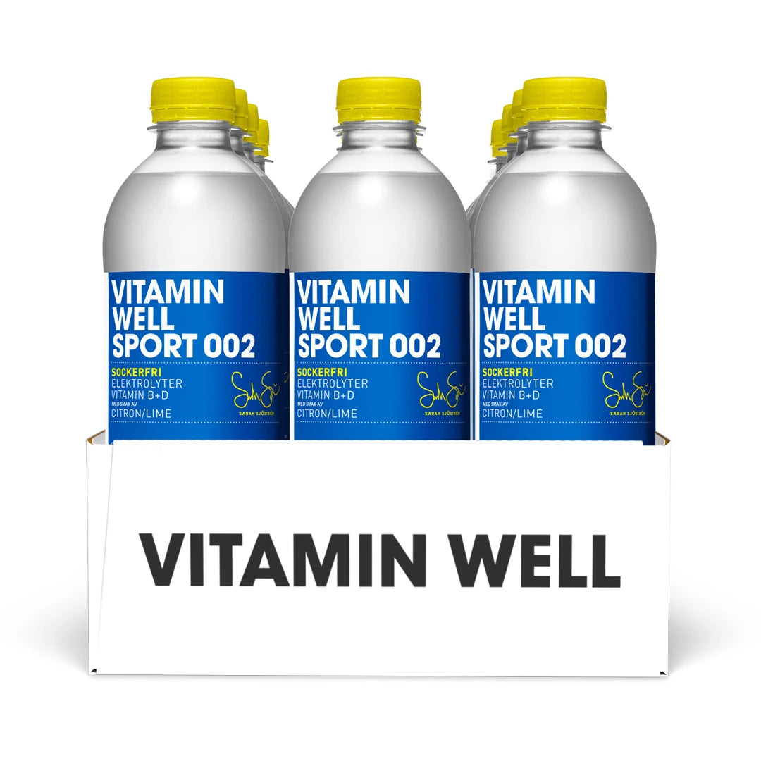 12 x Vitamin Well Sport 500 ml 002 - Lemon Lime (sockerfri) i ett vitt flak med flaskor, blå etiketter och gula korkar.