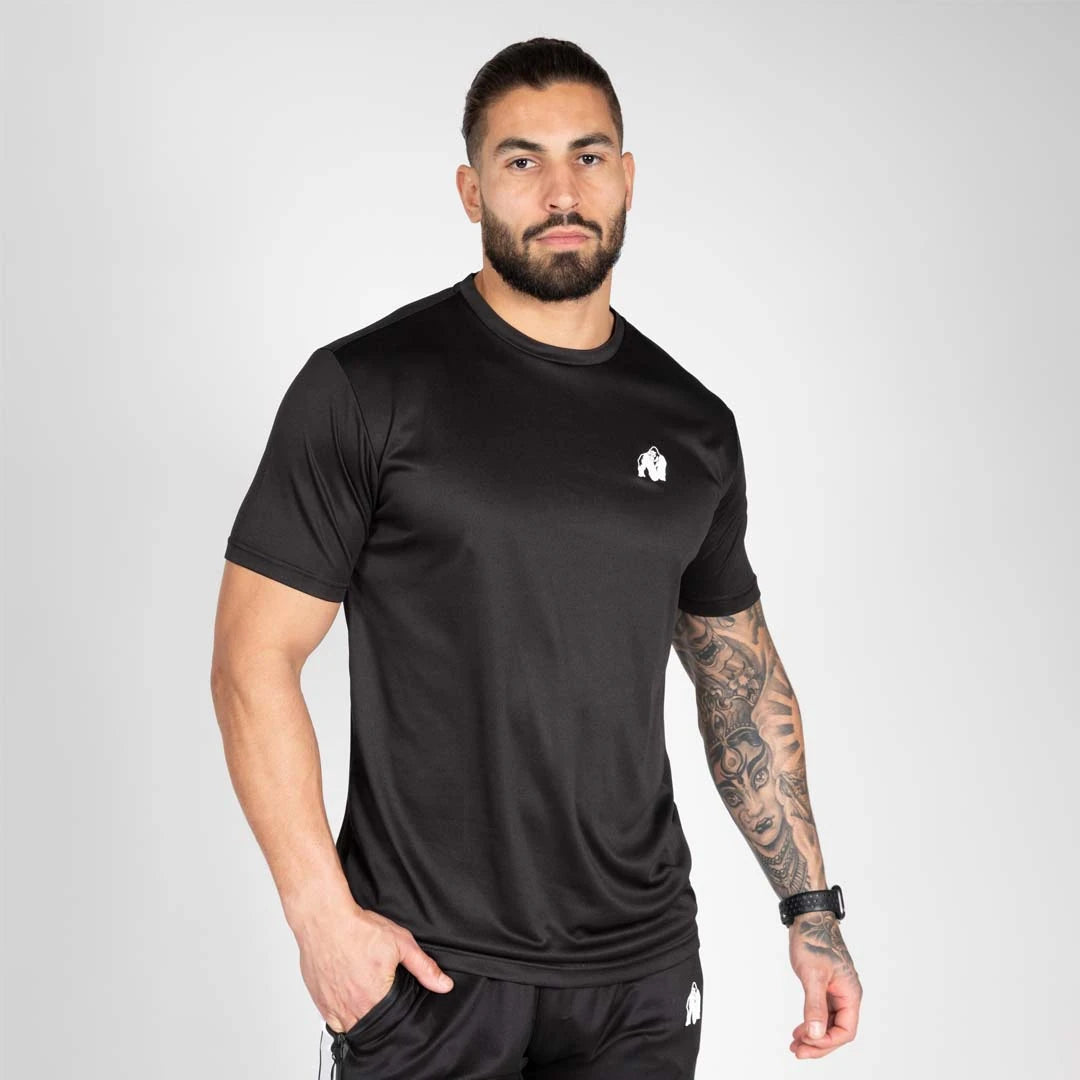 Gorilla Wear Fargo T-Shirt Black, en svart träningströja i luftig polyester med vit logga, buren av en modell., bild 2 av 2