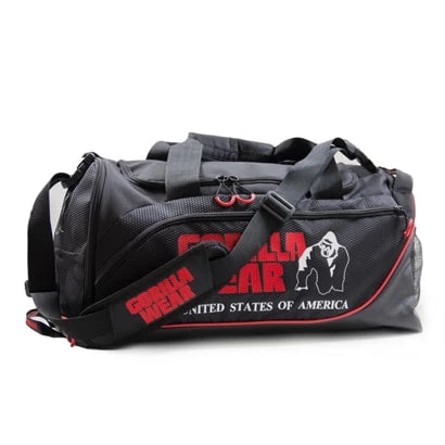 Svart Gorilla Wear Jerome Gym Bag i slitstark polyester med röda logotyper, bärhandtag och axelrem för träning.