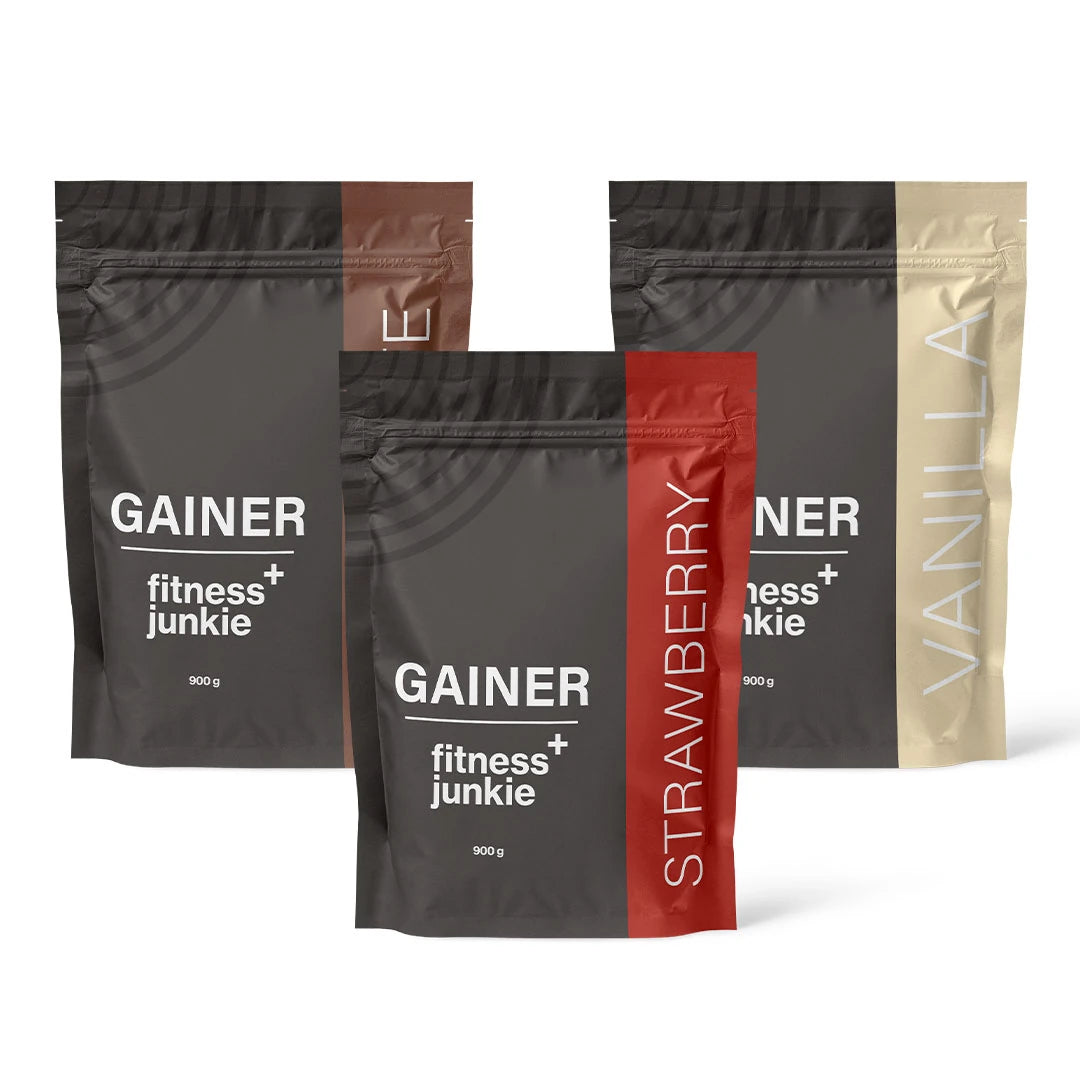3 x fitnessjunkie Gainer 900 g svarta påsar med bruna, röda och beigea detaljer för smakerna Choklad, Jordgubb och Vanilj.