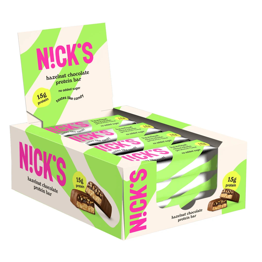 12 x NICKS Soft bar 50 g Hazelnut Chocolate i en vit displaybox med ljusgröna detaljer och rosa logotyp.
