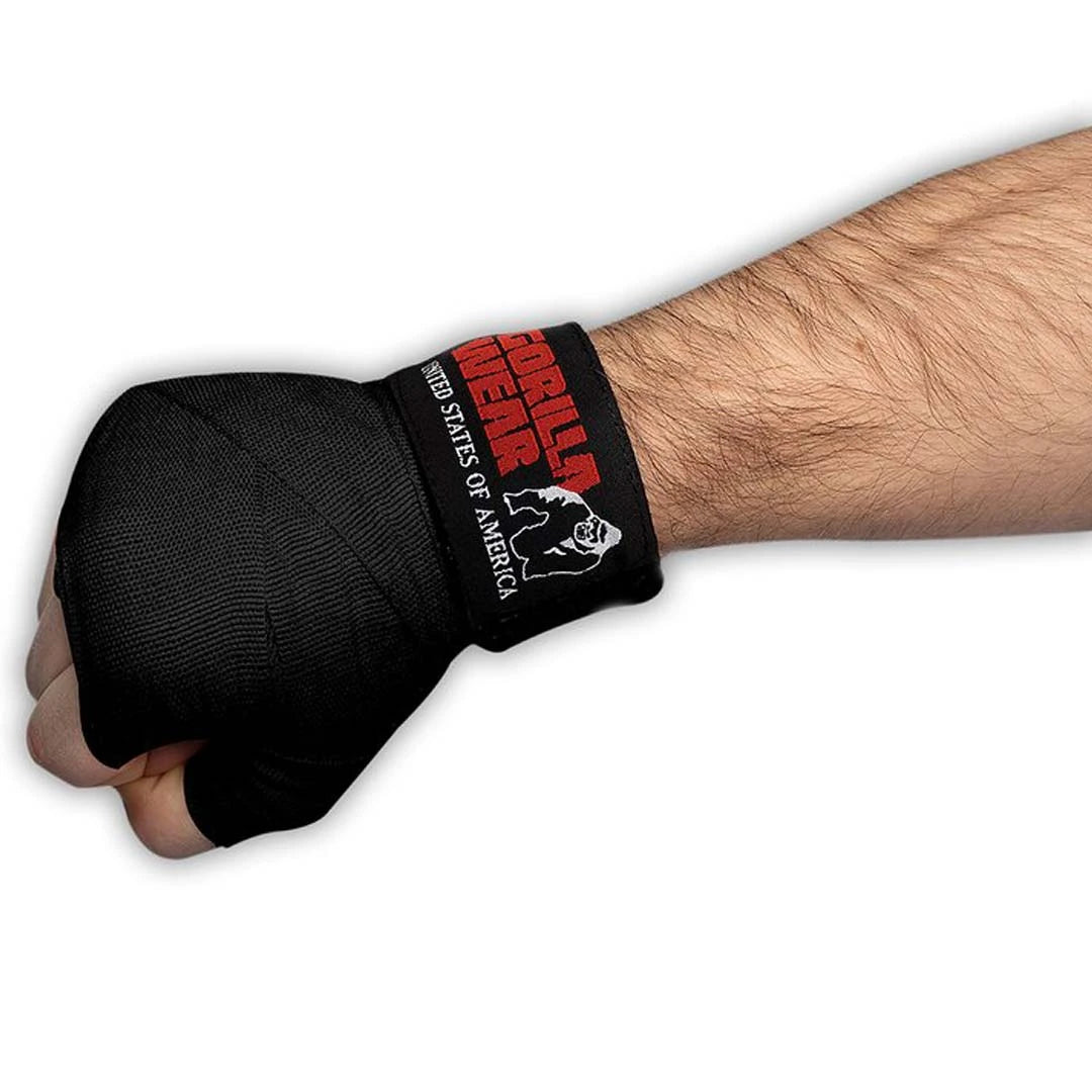Svart Gorilla Wear Boxing Hand Wraps lindade runt en knuten näve, med röd logotyp och text på handleden.