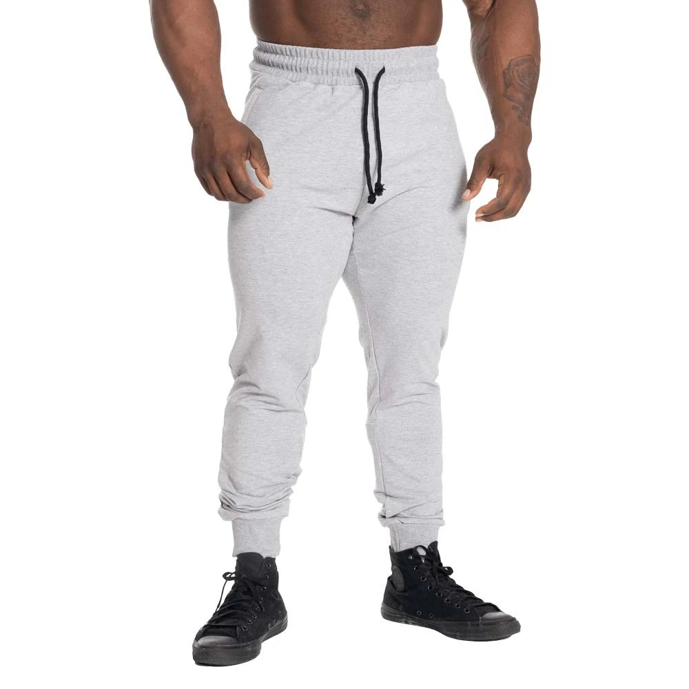 GASP Tapered Joggers Light Grey Melange är ljusgrå träningsbyxor med avsmalnande passform och svart dragsko.
