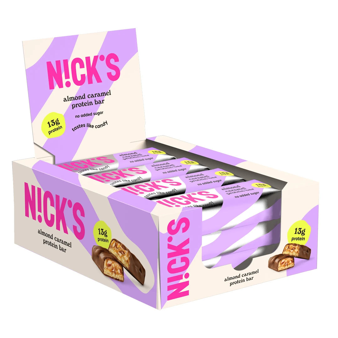 12 x NICKS Soft bar 50 g Almond Caramel i en lila och vit displaybox med matchande förpackningar.