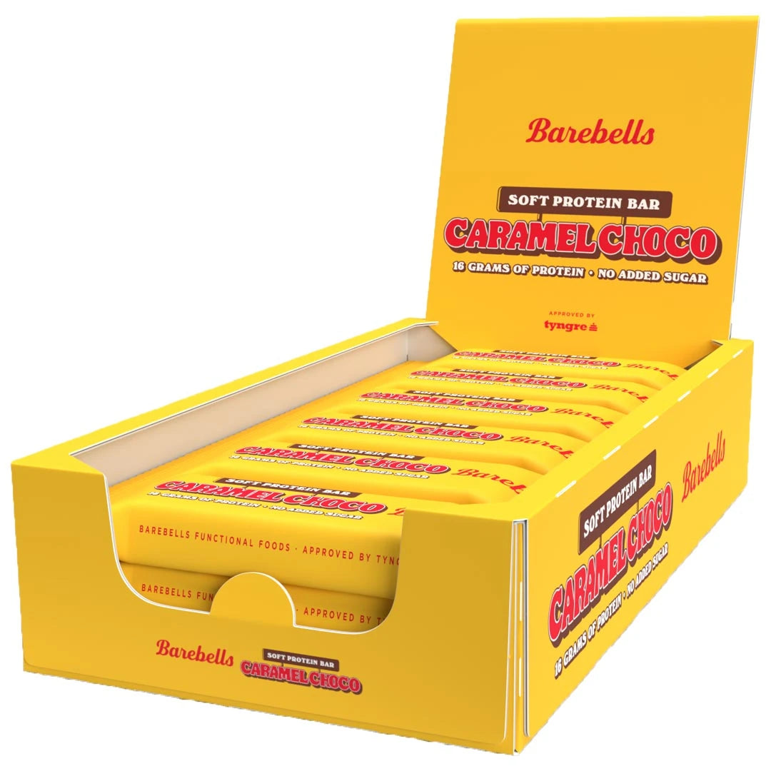 12 x Barebells Protein Bar 55 g Caramel Choco i en öppen gul displaylåda med röda detaljer.